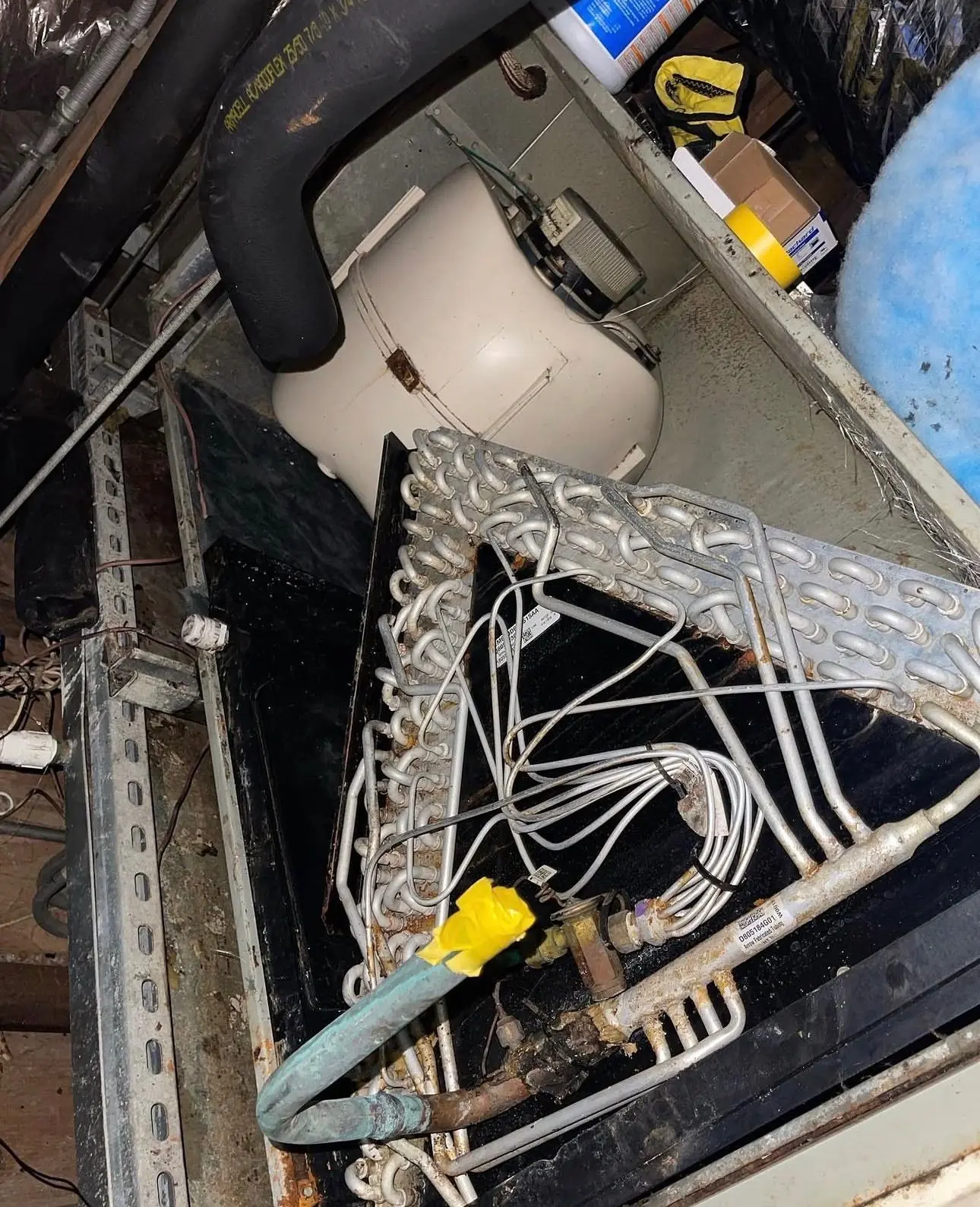 Evaporator coil exposed inside an opened indoor air handler cabinet
