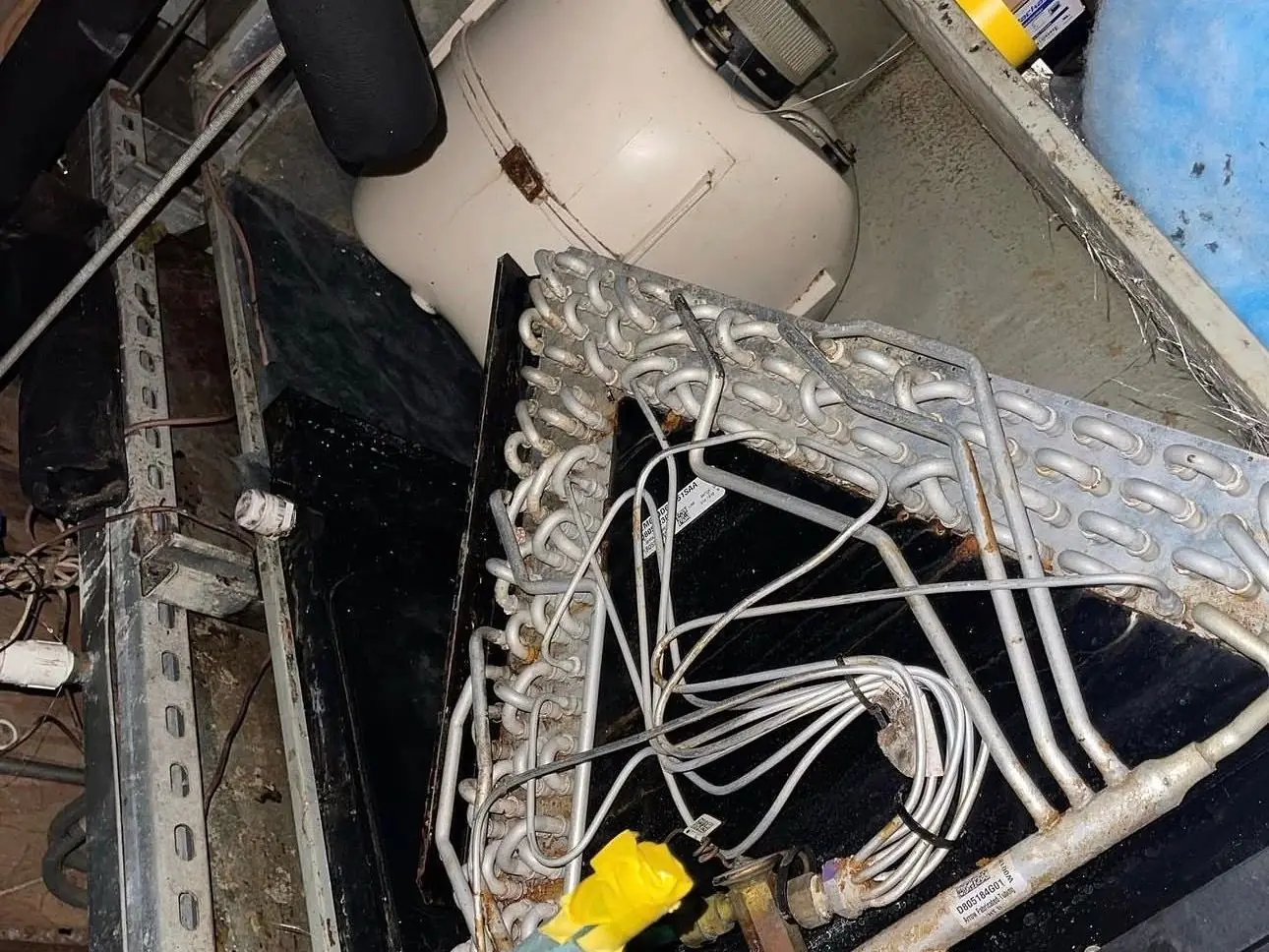 Evaporator coil exposed inside an opened indoor air handler cabinet