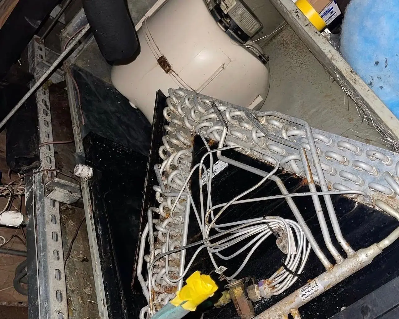 Evaporator coil exposed inside an opened indoor air handler cabinet