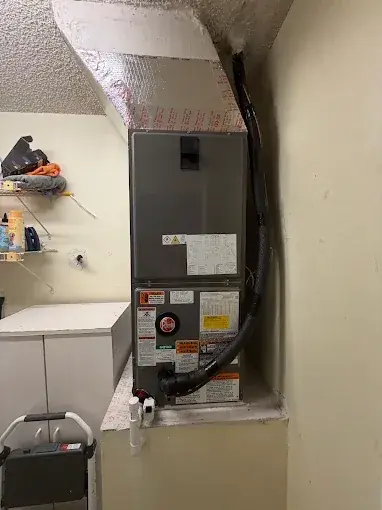 New air handler installed in a utility room, with an insulated plenum above it