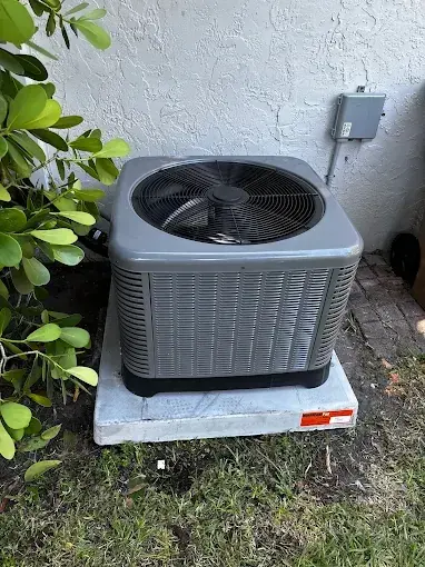 New outdoor condensing unit set level on its pad beside a house