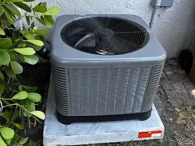 New outdoor condensing unit set level on its pad beside a house
