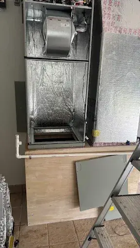 Air handler with its panels open, showing the blower, below a foil-insulated plenum