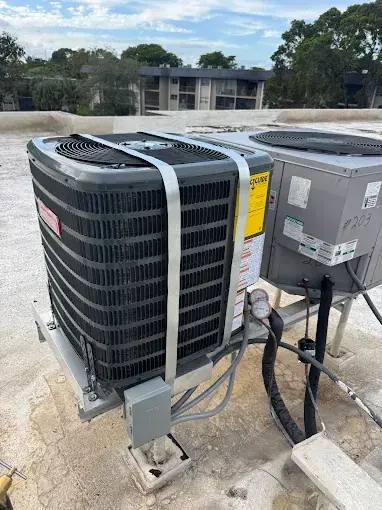 Rooftop condensing units on their stands, secured with hurricane straps