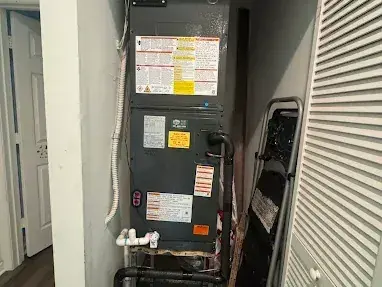 New air handler installed in a hallway closet with louvered doors