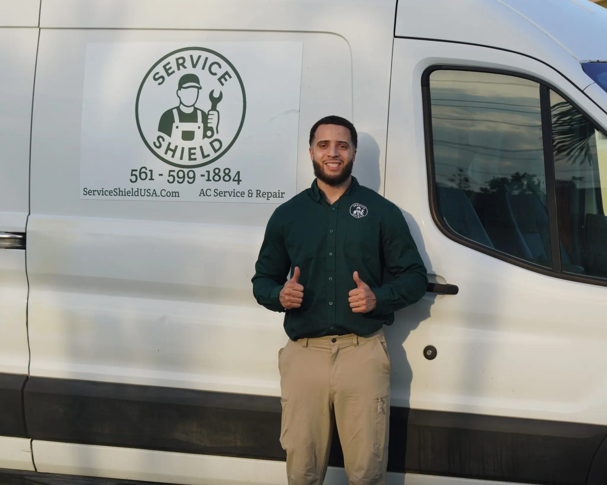 Service Shield technician standing beside a Service Shield service van
