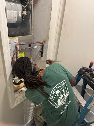 Service Shield technician brazing the copper refrigerant connections at an air handler