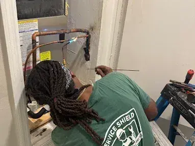 Service Shield technician brazing the copper refrigerant connections at an air handler