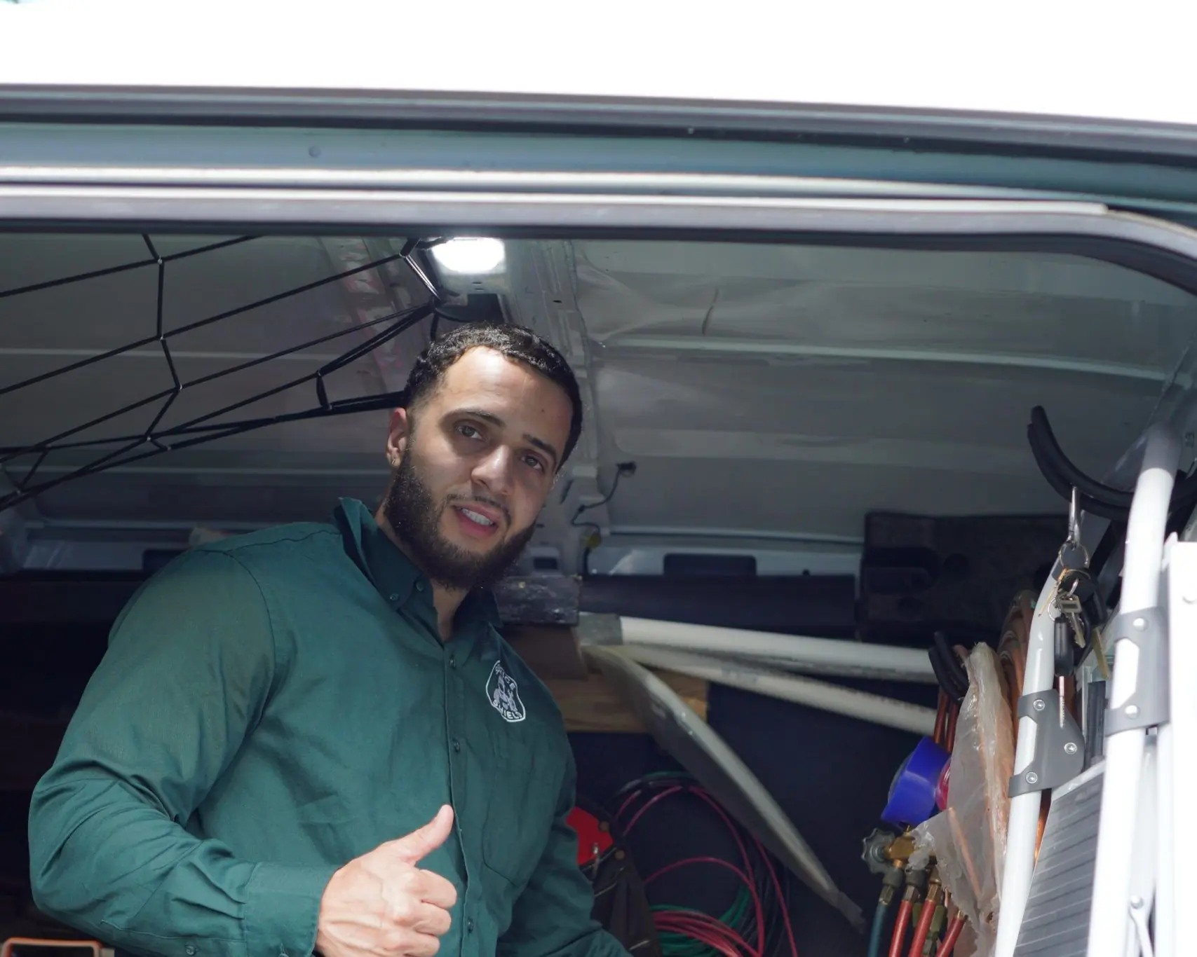 Service Shield technician at the open side door of a stocked service van